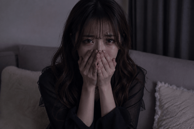 口元を押さえて泣く女性