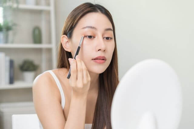アイメイクをする若い女性