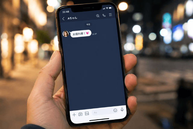 「お疲れ様」と連絡が来ているスマホを持つ男性の手元