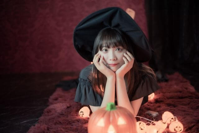 魔女のコスプレをした女性と装飾