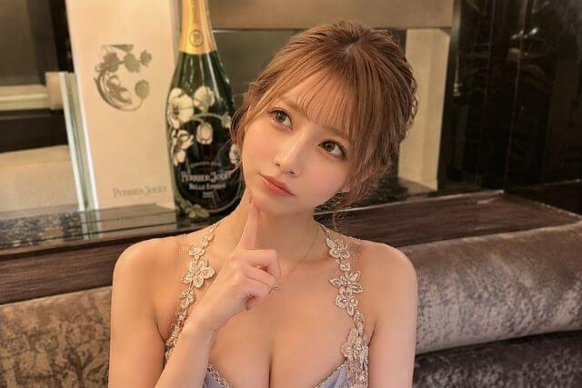 顎に人差し指を当てて、首を傾げて斜め上を見る女性