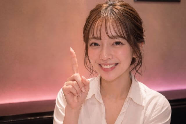 人差し指を立てる女性