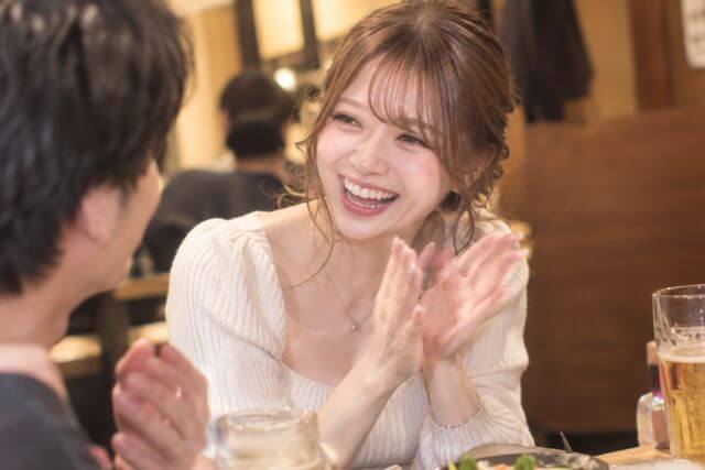 手を叩いて話を聞く笑顔の女性