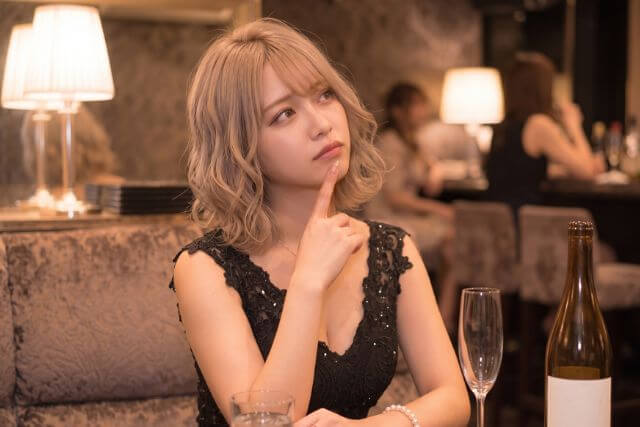 困った顔で首をかしげるキャバ嬢