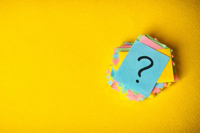 カラフルな髪が積み重ねられている。1番上に水色の紙に？のマーク