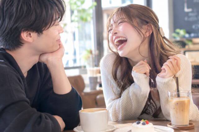 口を開けて笑う女性と微笑む男性