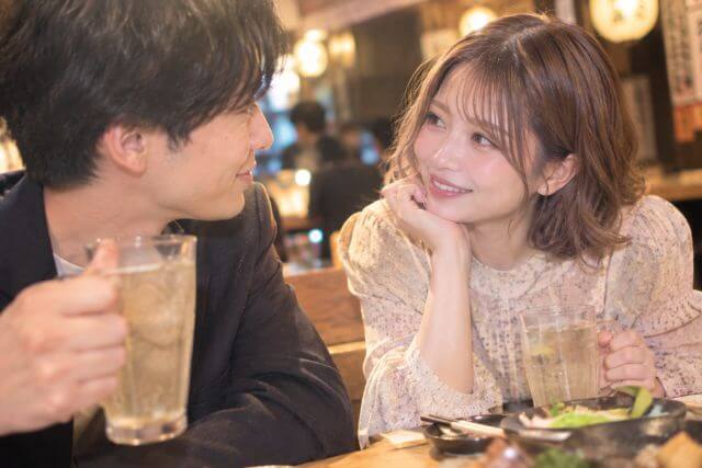 男性を見つめる女性とお酒を持つ男性