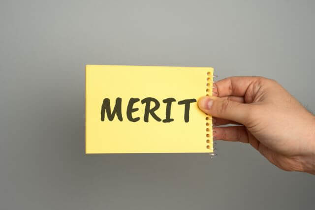 MERITと書かれた黄色い紙を持っている人の手元