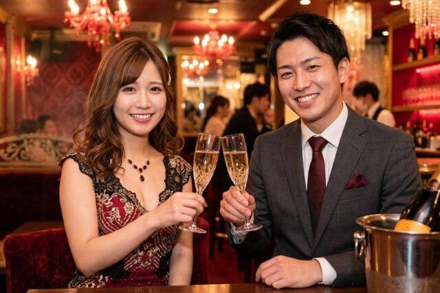 キャバクラでシャンパンで乾杯するキャバ嬢と若い男性客