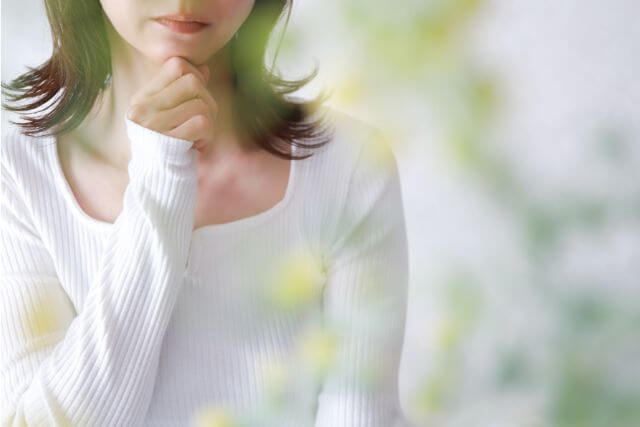 顎に手を当てている女性の口元