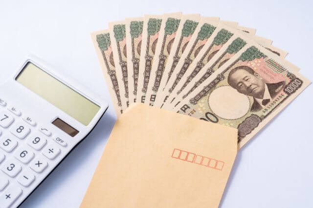 封筒に入ったたくさんの一万円札と電卓