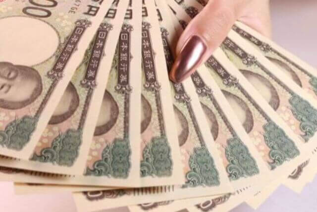 万札を広げている女性の手元