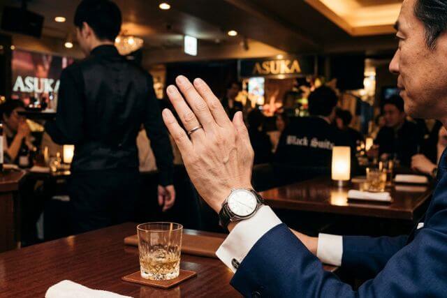 手を挙げている男性の手元