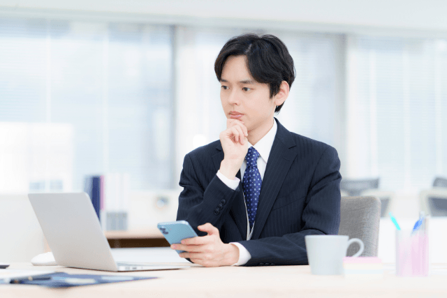 スールの男性が顎に手を当てて考え事をしている