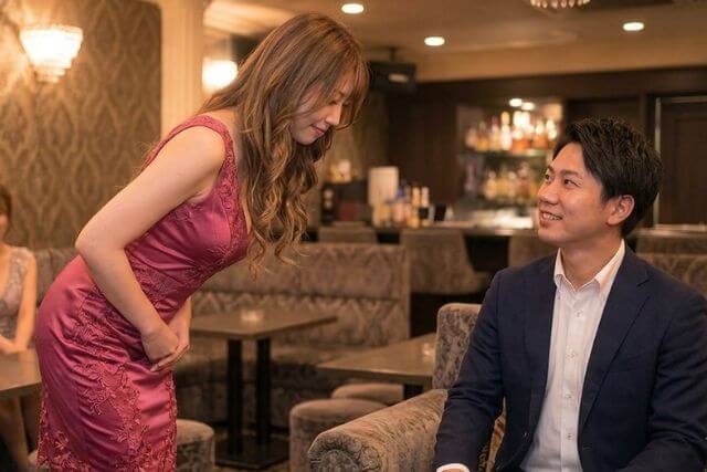 スーツの男性にお辞儀するキャバ嬢