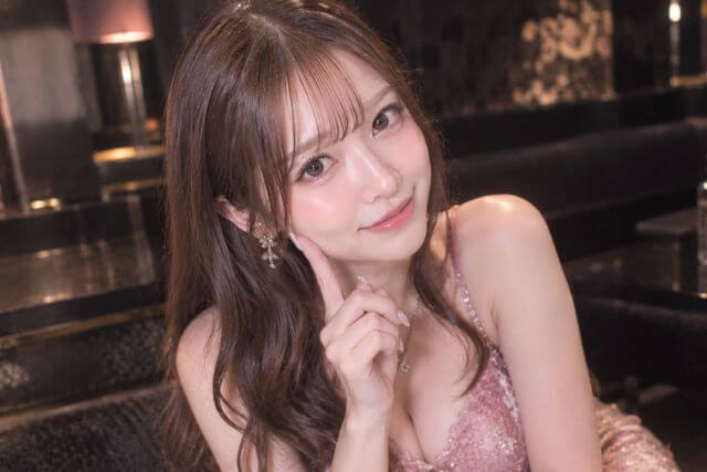 頬に指を当てる笑顔のキャバ嬢