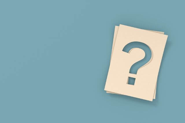 水色の背景に?がくり抜かれた白い紙