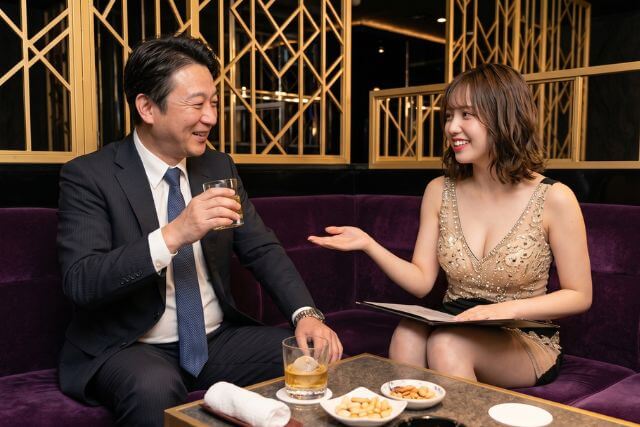 楽しそうに飲んでいる男性に、笑顔で話しかける女の子