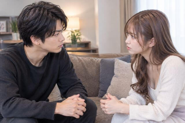 ソファに座って向き合って話す男女