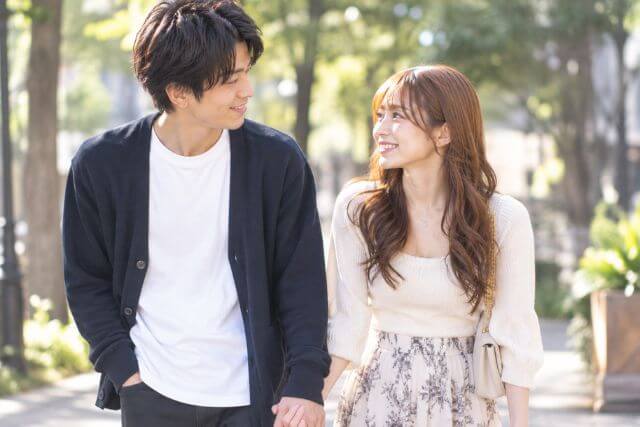 若い男女が手を繋いで外を歩いている