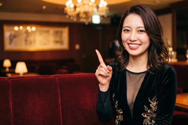 人差し指を立てる女性