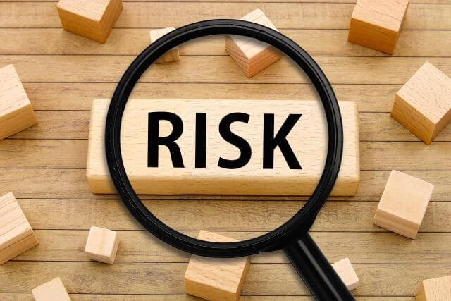 ブロックに書かれたRISKの文字と虫眼鏡