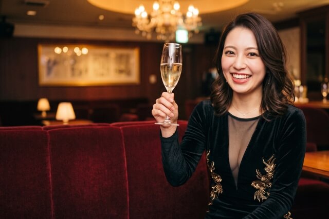 シャンパングラスを掲げる女性