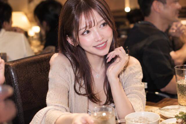 肘をついて話すロングヘアの女性