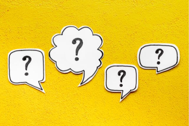黄色い背景にいろんな形の吹き出し。中には?マーク
