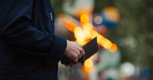 夕方の屋外で財布を開く男性の手元