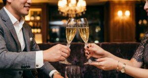 シャンパングラスを持って乾杯するキャバ嬢と男性客の手元