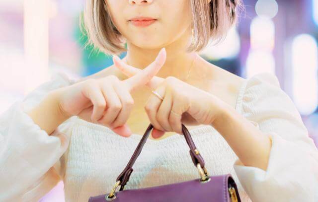 NGサインを出す女性の手元