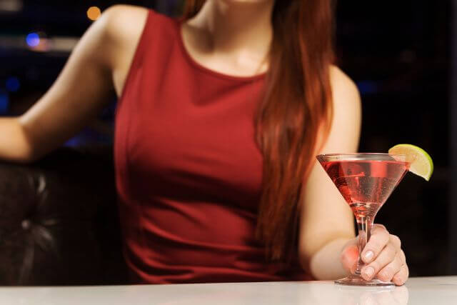 カクテルを持つ赤いドレスを着た女性