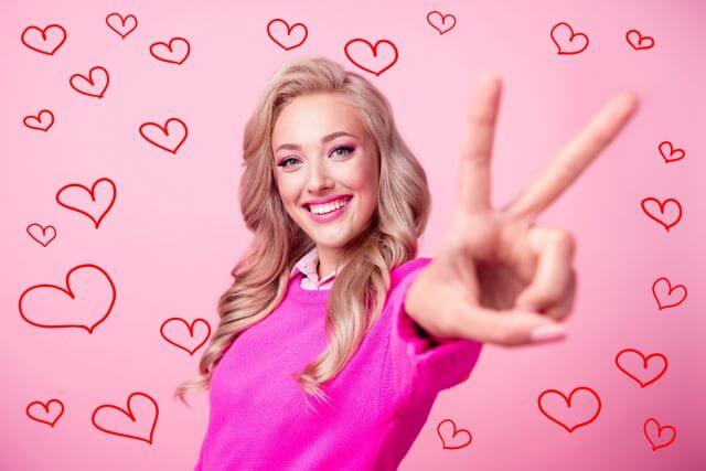 ハートが書かれた中でピースをする女性