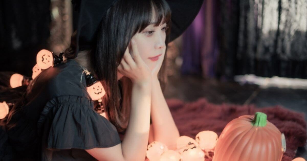 魔女のコスプレをして横になる女性
