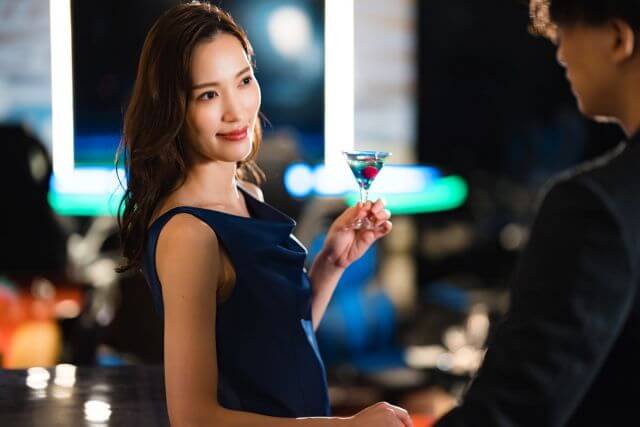 お酒を持ちながら話している男女