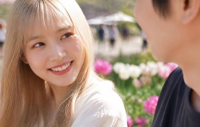 かわいく男性にほほ笑む金髪日本人女性