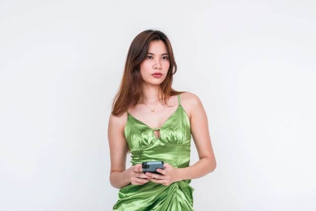 携帯を持ち悩んでいる女性