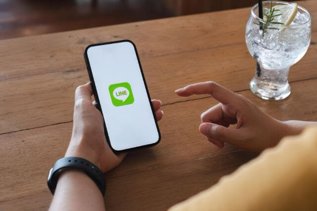 LINEマークが表示されたスマホを触る手