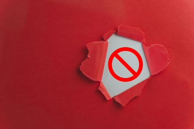 赤い背景の中から出る注意マーク