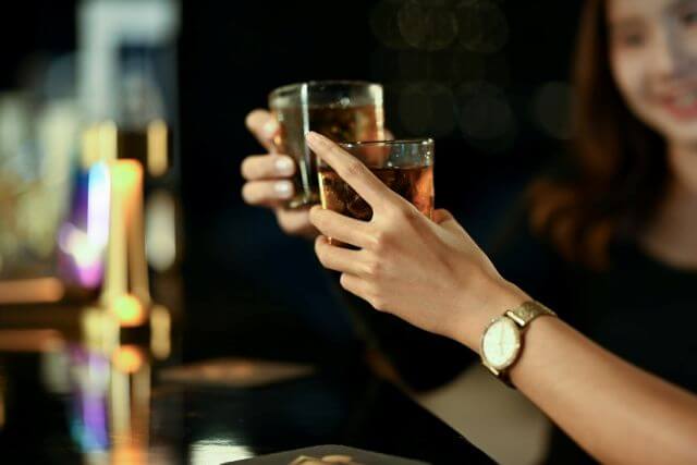 ウイスキーで乾杯する女性の手