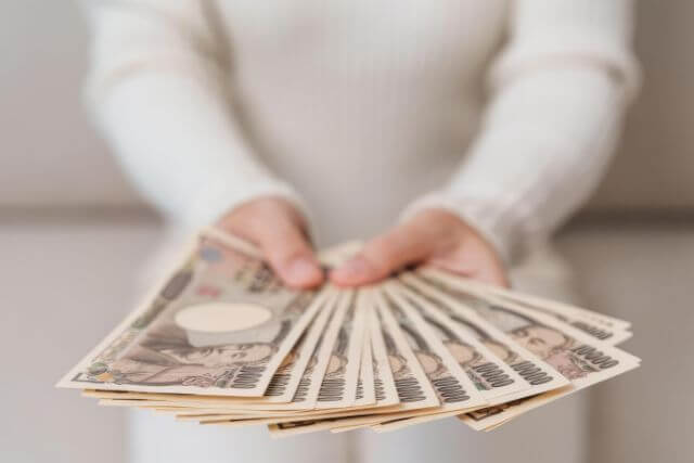 札束を持つ女性の手