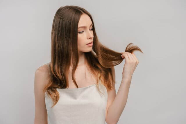 髪の毛を気にする女性
