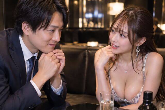 男性が女性の方を少しだけ笑顔で見ている様子。キャバ嬢も優しい笑顔で会話している様子。
