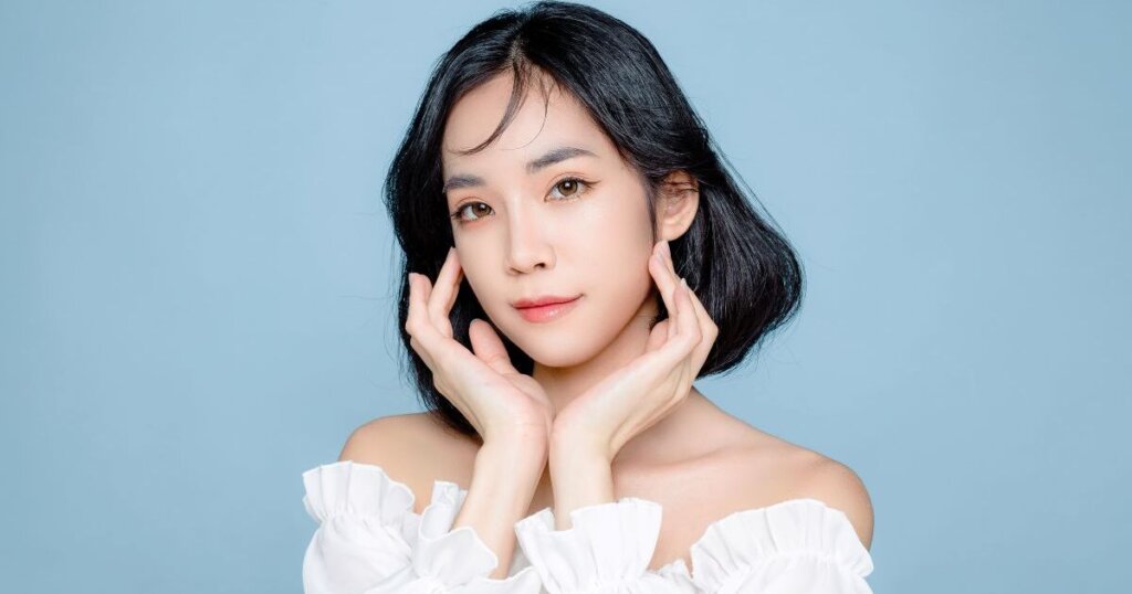 顔をおさえてポーズする黒髪の女性