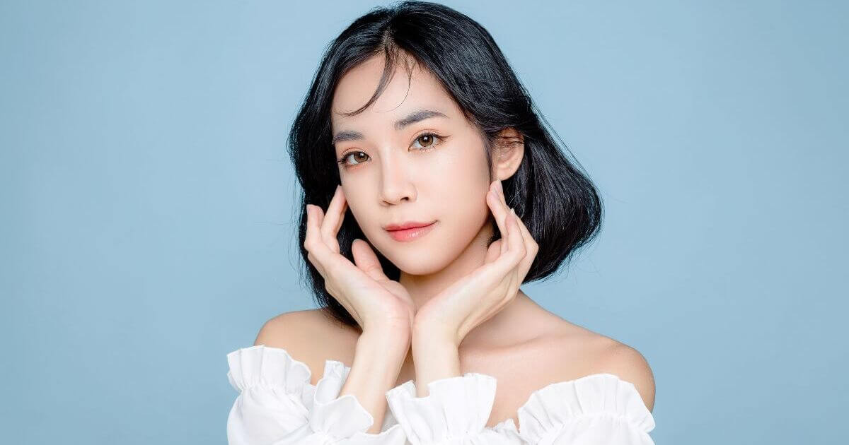 顔をおさえてポーズする黒髪の女性