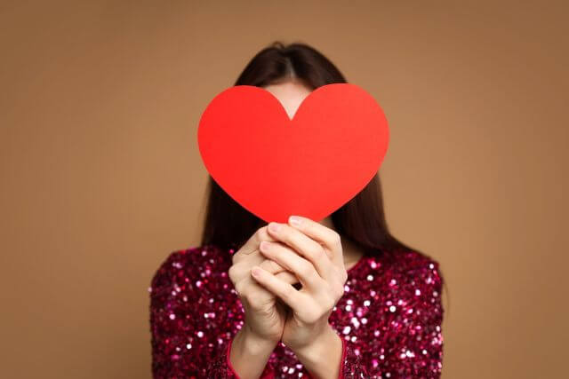 顔の前でハートを持つ女性