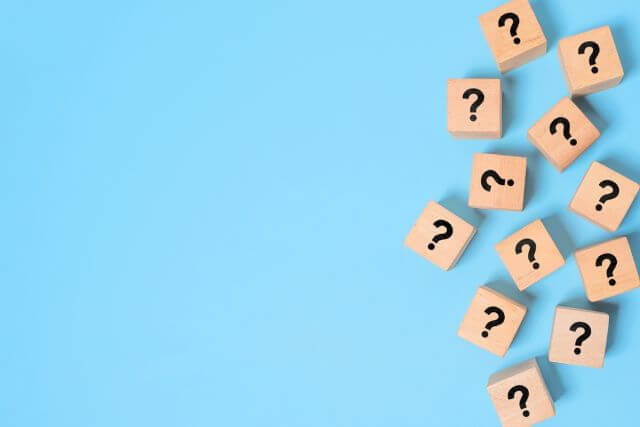 青い背景の前にあるハテナマーク