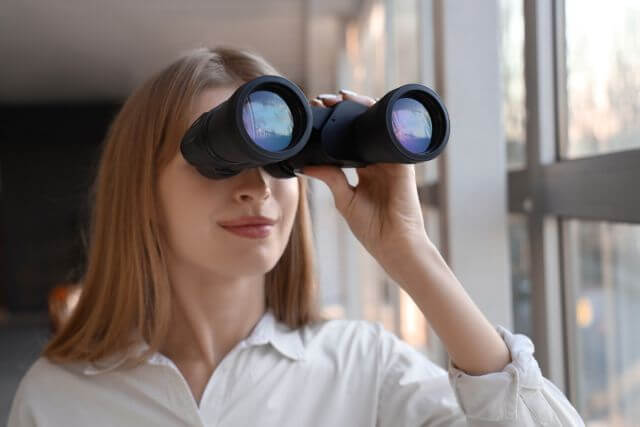 双眼鏡で見る女性