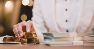 金塊と札束を触る女性